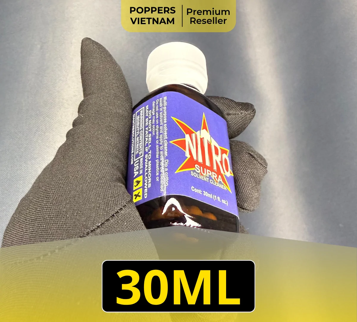 Chai popper Nitro 30ml với màu xanh dương nổi bật vì nằm trên găng tay màu đen - được chụp bằng máy ảnh chuyên nghiệp mang lại cảm giác sang trọng