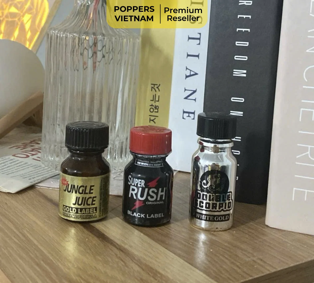 Hình ảnh 3 chai poppers đã tháo hờ nắp và được đặt thẳng đứng trên kệ bàn gần giường ngủ.