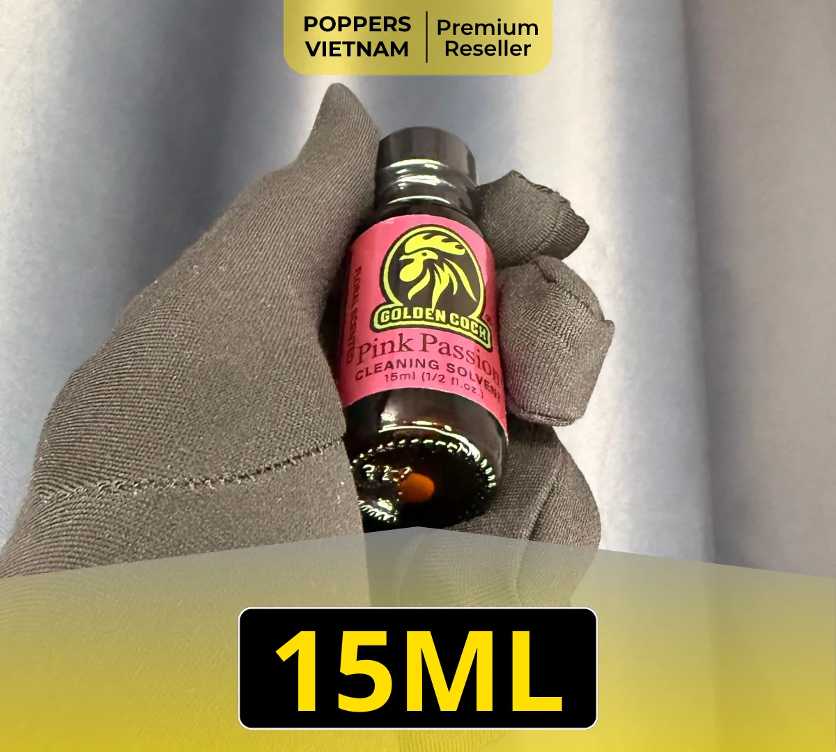 Hình ảnh chai Popper Golden Cock Pink Passtion 15ml được chụp trên găng tay và phông nền xám.