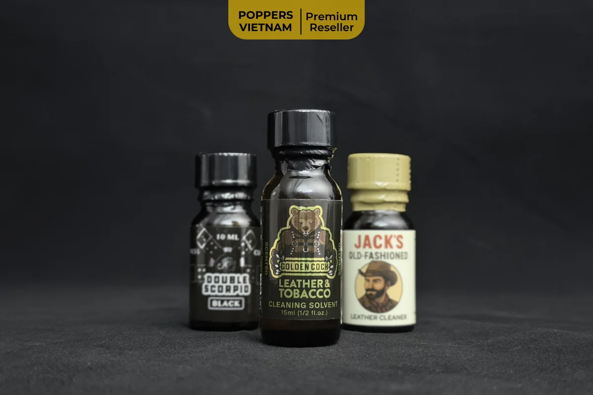 Hình ảnh là 3 chai poppers mùi Leather được Poppers Việt Nam review. Ảnh chụp chai Golden Cock Leather & Tobacco được lấy nét, 2 chai còn lại làm mờ đi.